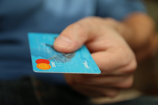 Close up of a persons hand holding a bank card